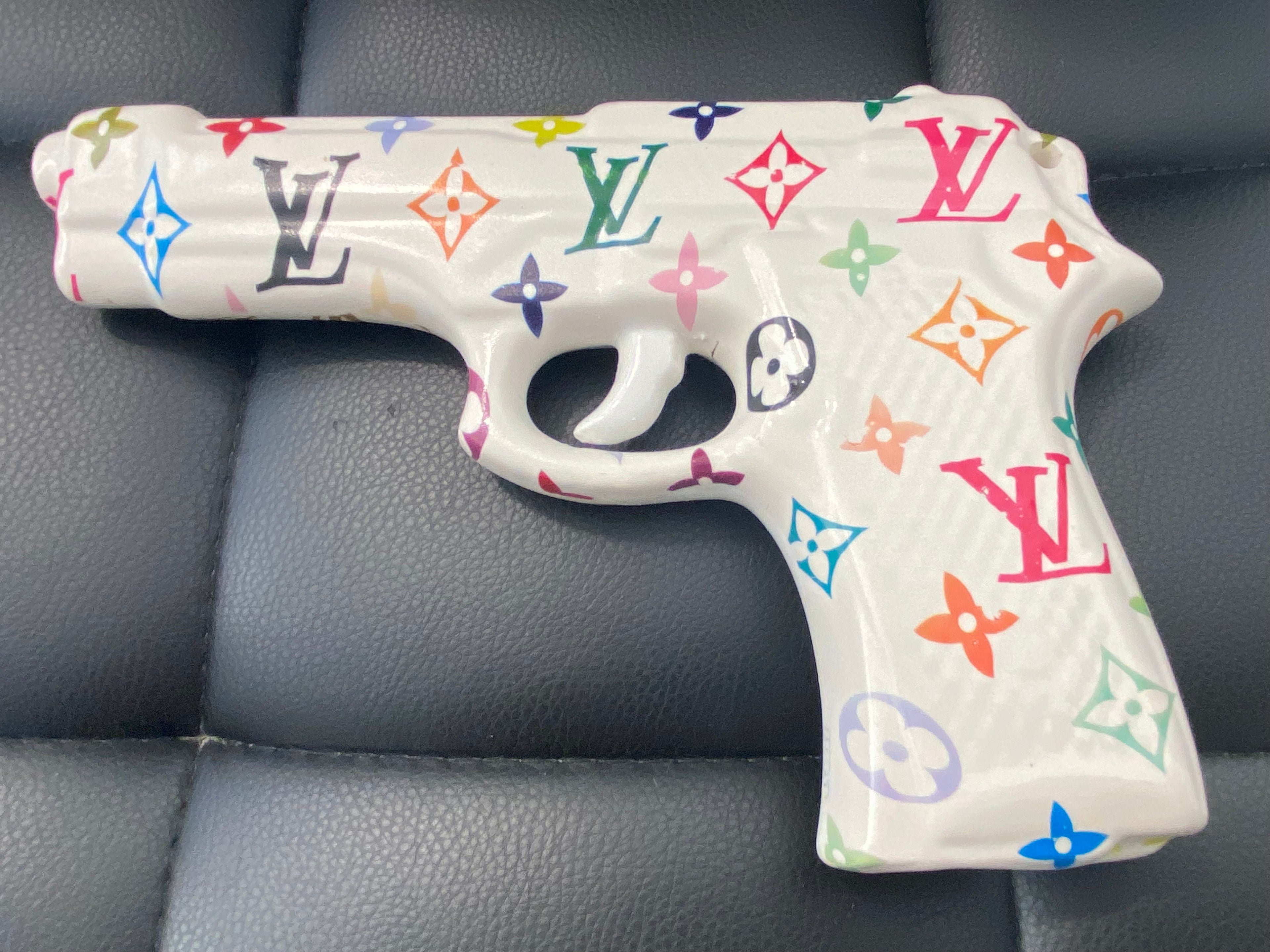 Opera pop art MY GUN n.1 in porcellana, design ispirato al lusso con dettagli colorati, vista dall’alto.