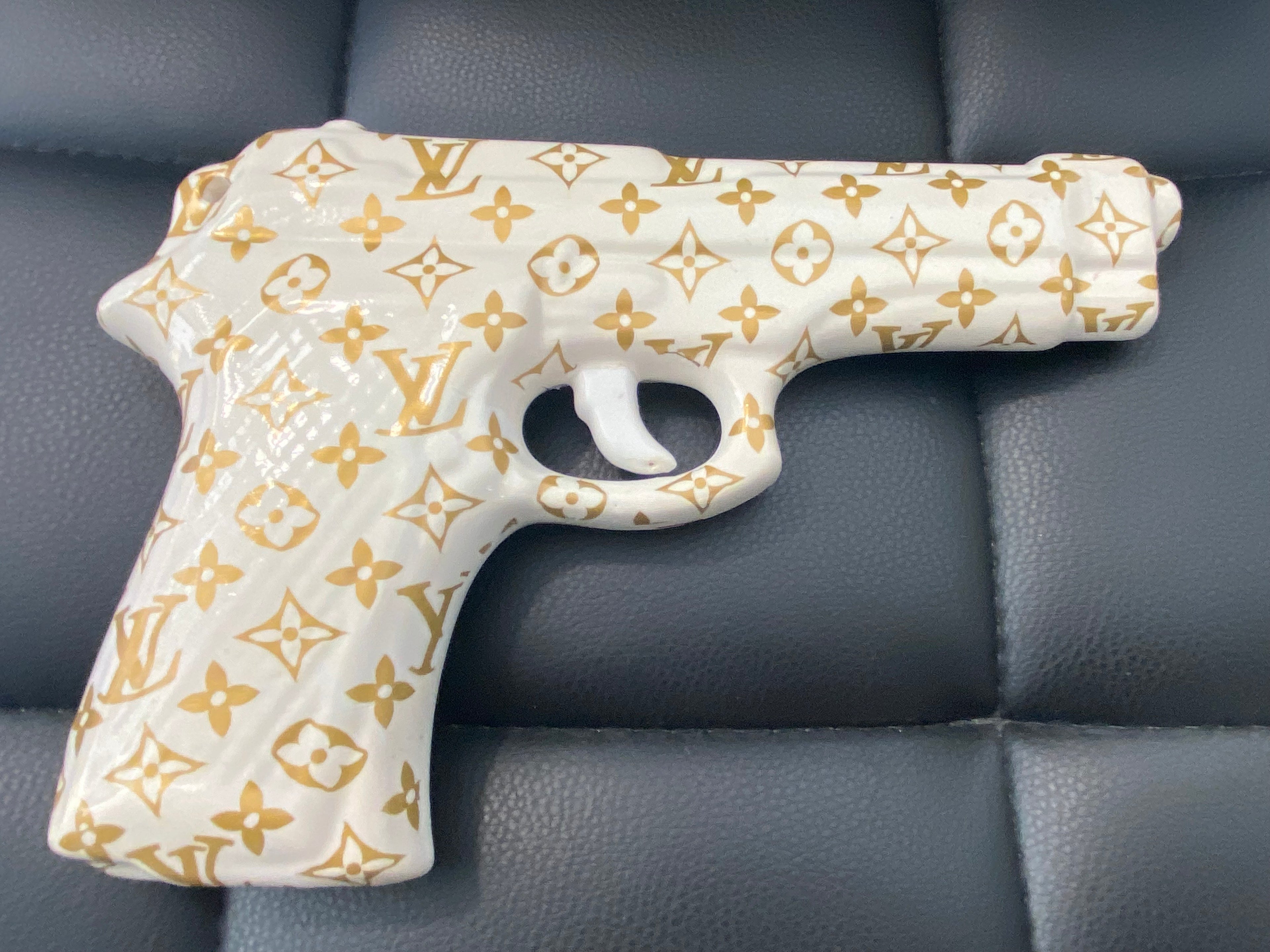 Opera pop art MY GUN n.1 in porcellana bianca con pattern oro, acrilico & wrapping, vista laterale.