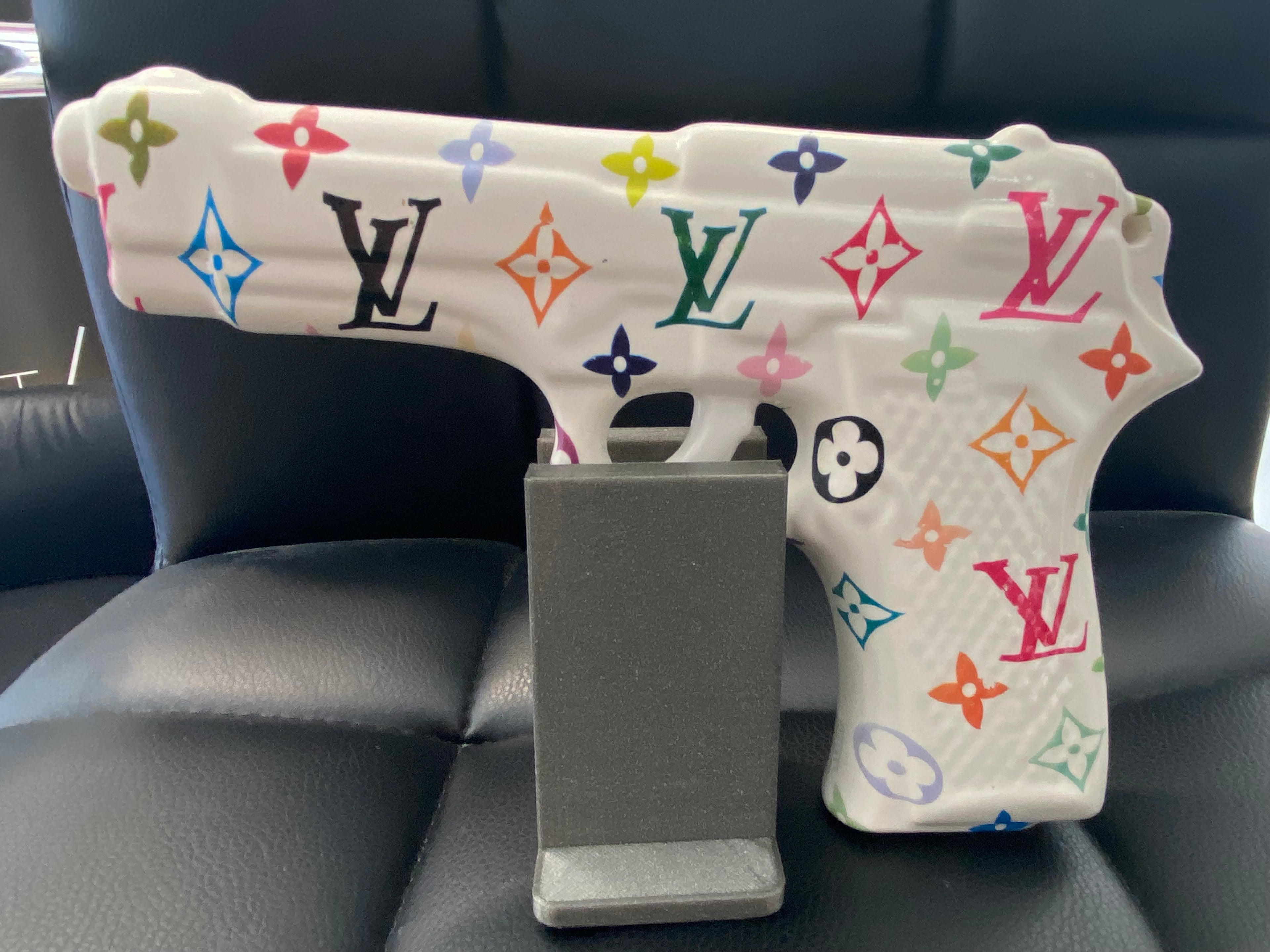 Opera pop art MY GUN n.1 in porcellana bianca con motivi colorati, acrilico & wrapping, vista laterale.