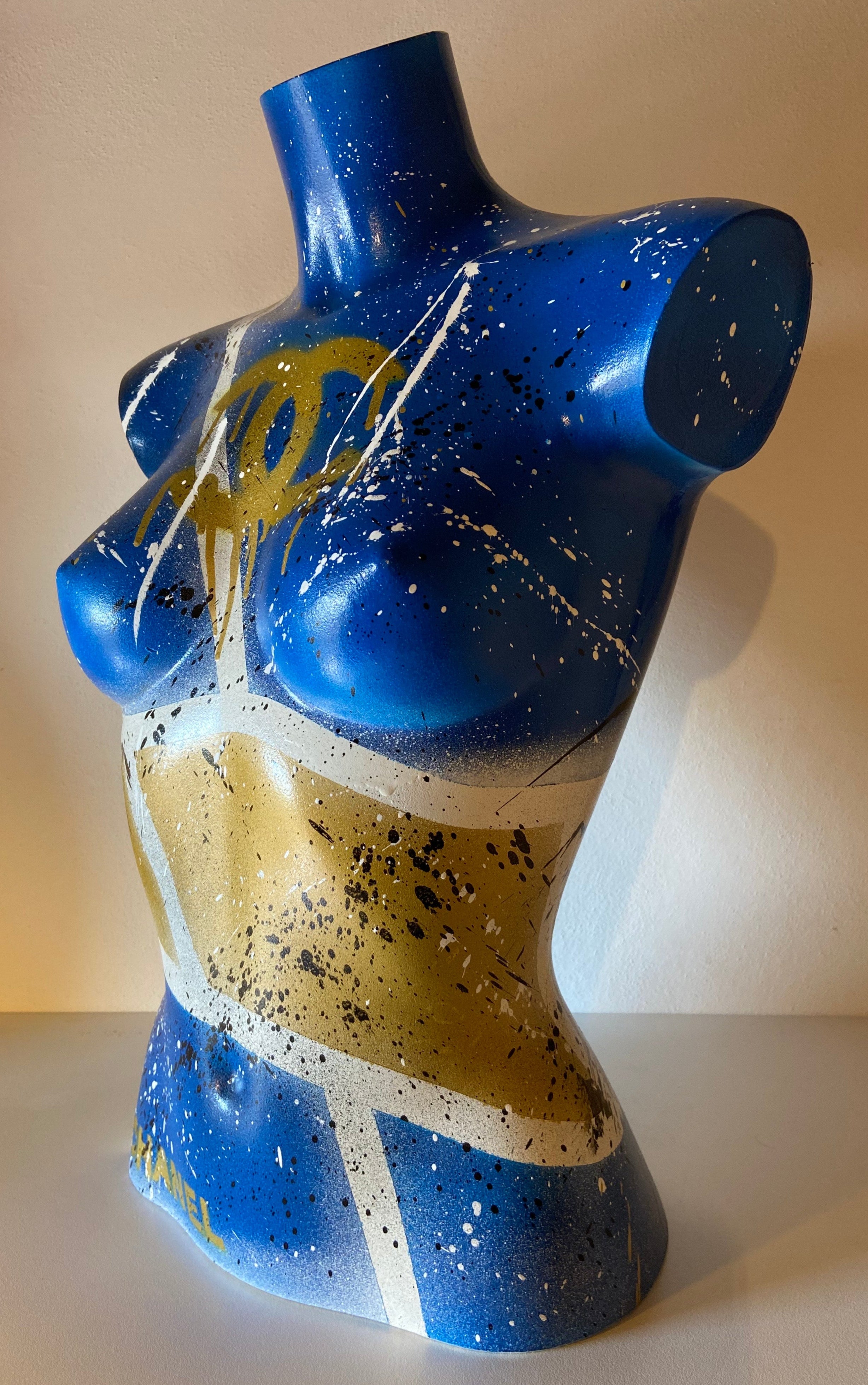 Vista laterale della scultura Lady Chanel 2024, torso femminile blu e oro in plastica dipinta a mano, tecnica spray acrilico.