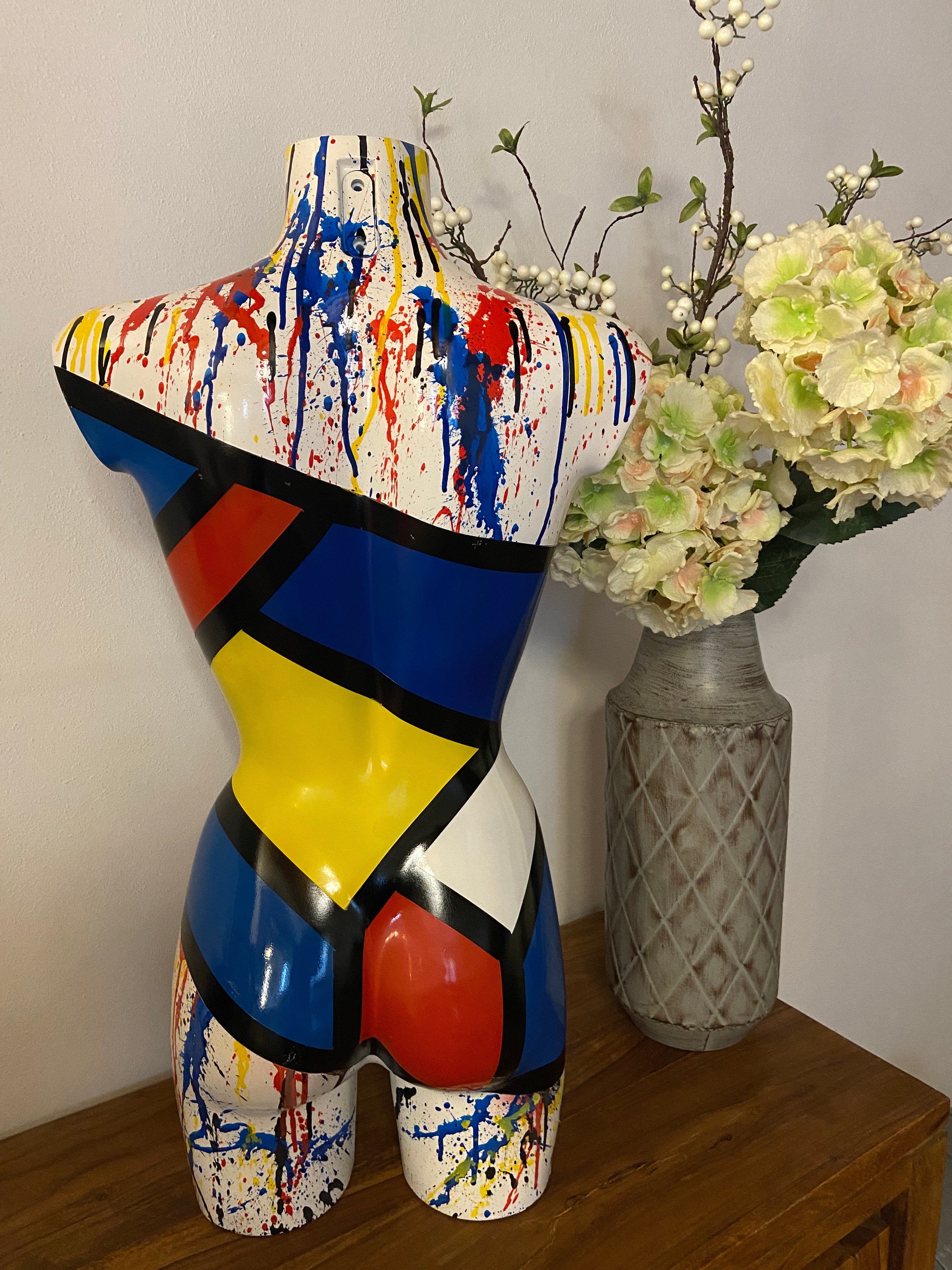 Retro della scultura Miss Mondrian, torso femminile in resina, decorato con colori primari e colature astratte.